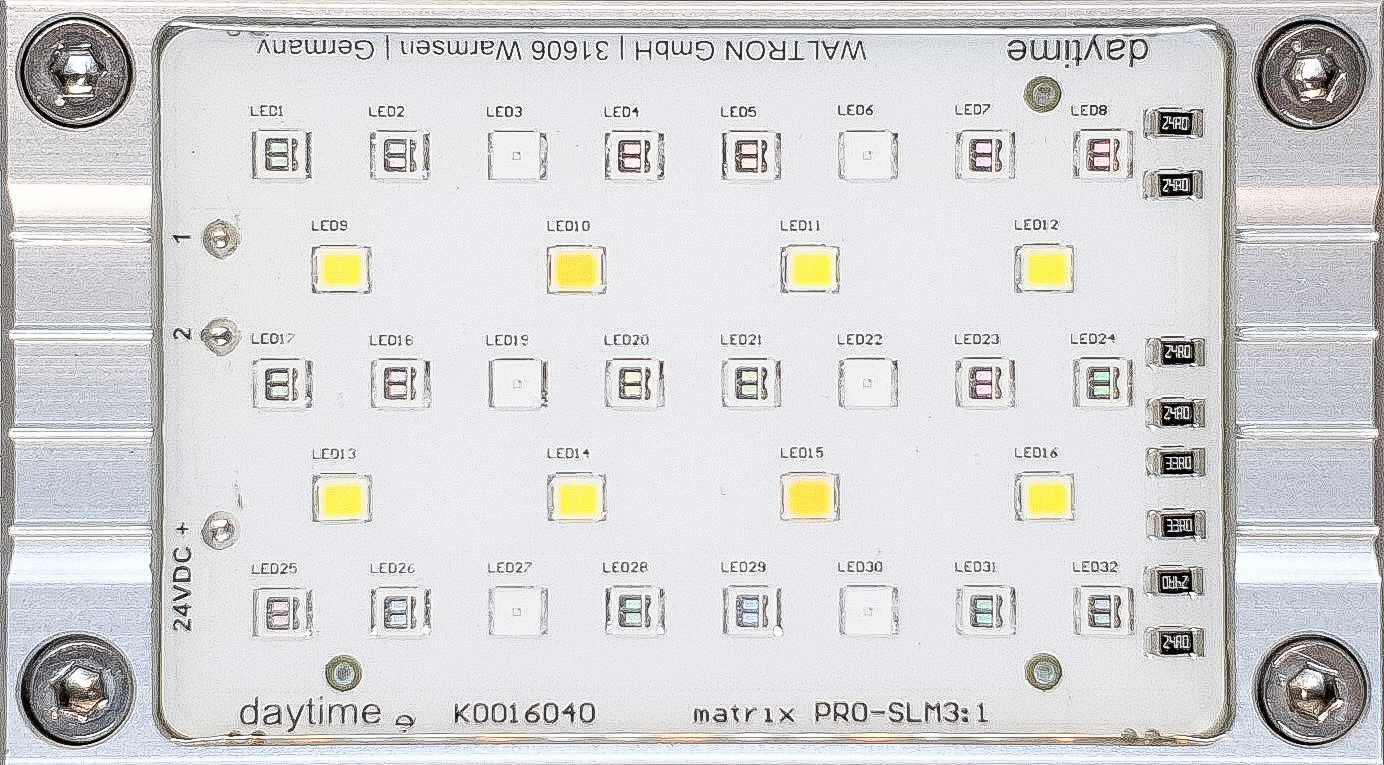 daytime Module matrix PRO dans un cadre argenté avec carte électronique blanche. Rangées de LED jaune clair à spectre complet et de LED bleu royal plus foncées. Lumière brillante bleutée, fluorescence optimale en aquarium marin.